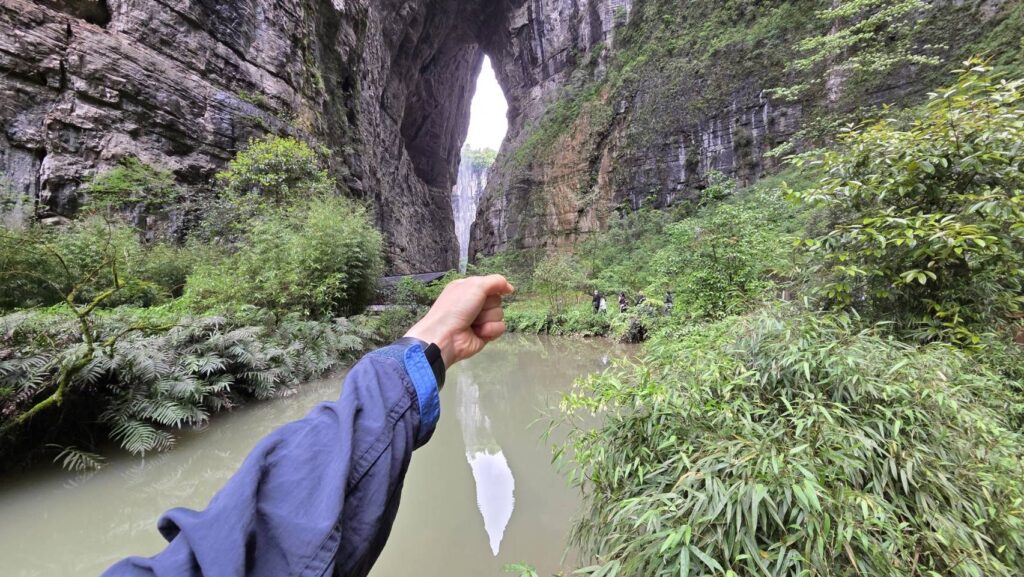 剣のような形に見える光の影・剣を持つポーズで撮影する観光客